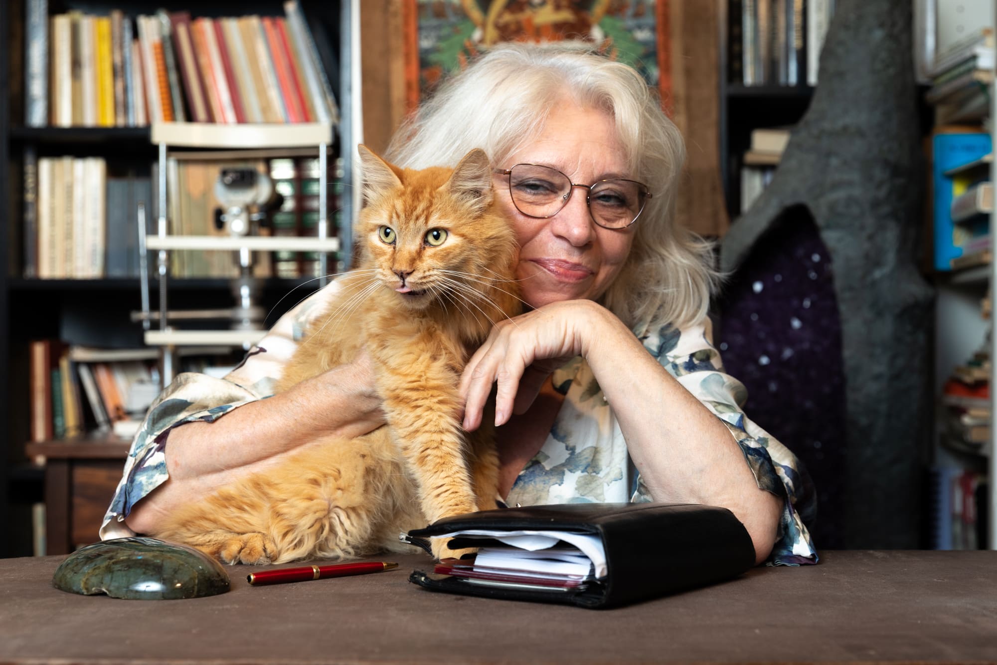 Vittoria Fornari nel suo studio, sorridente con il suo gatto rosso in braccio